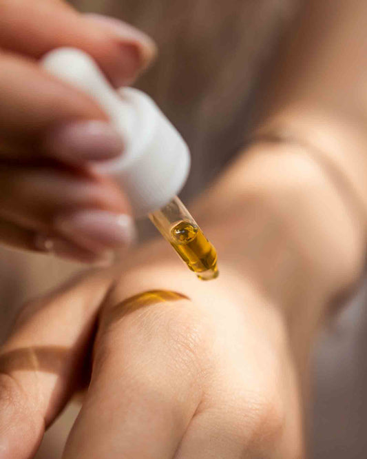 Woman using infused oil on hand